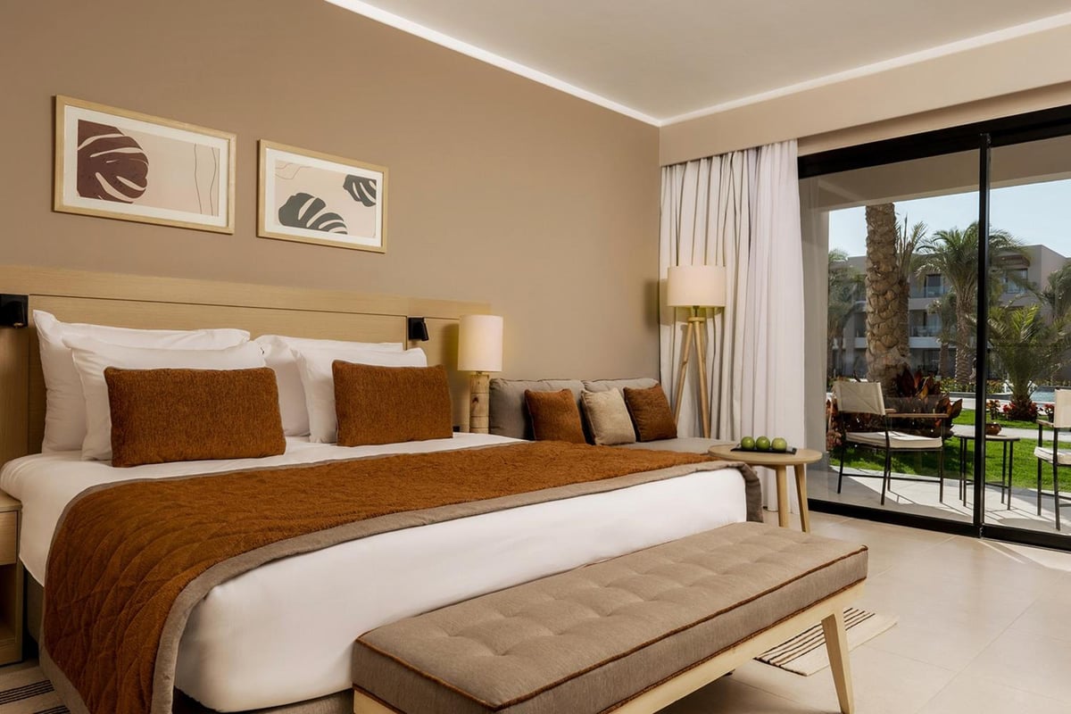 JAZ Elite Amara bedroom with a wide bed and sliding glass doors.