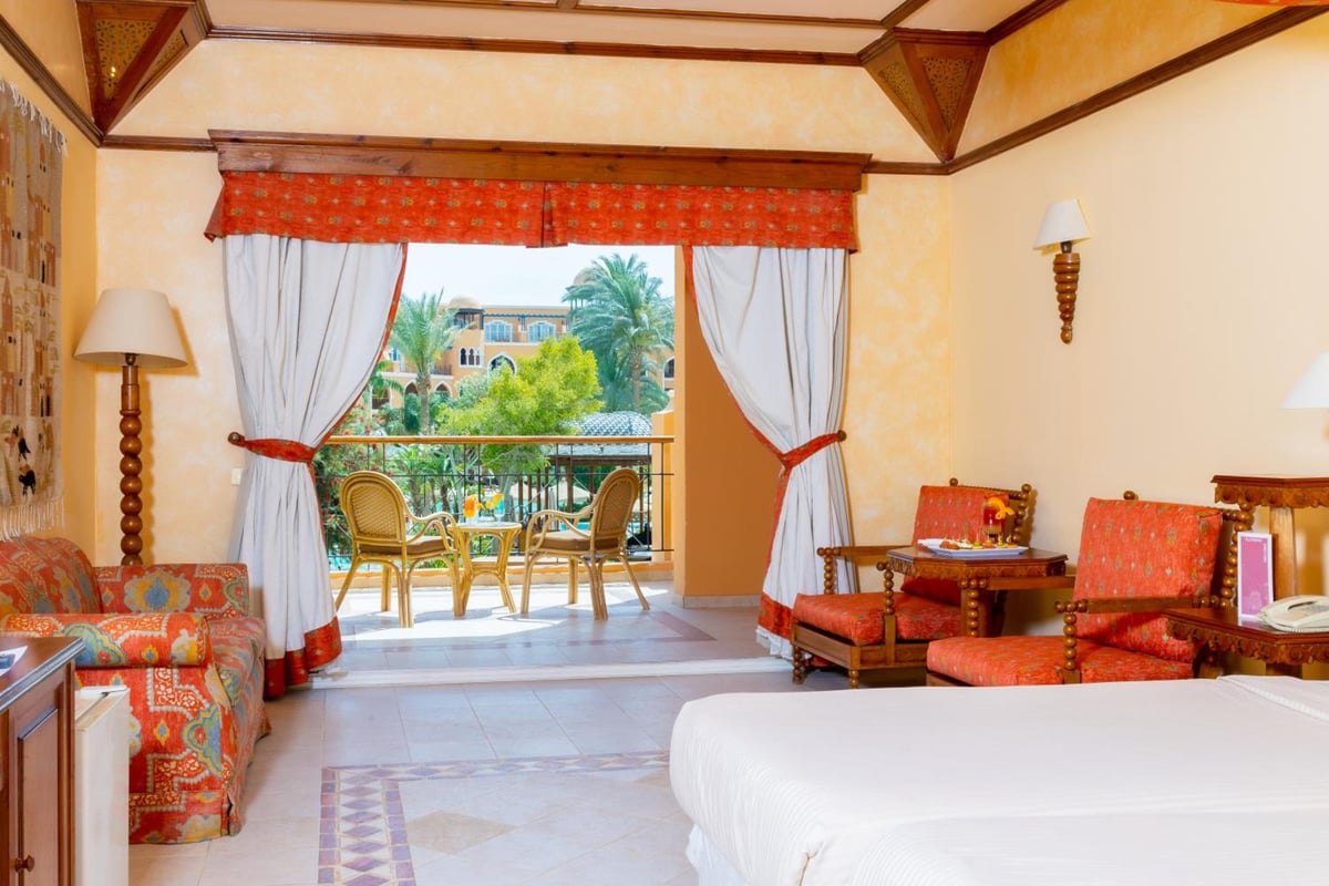 The Grand Resort Hurghada guest room with a bed and open balcony doors.