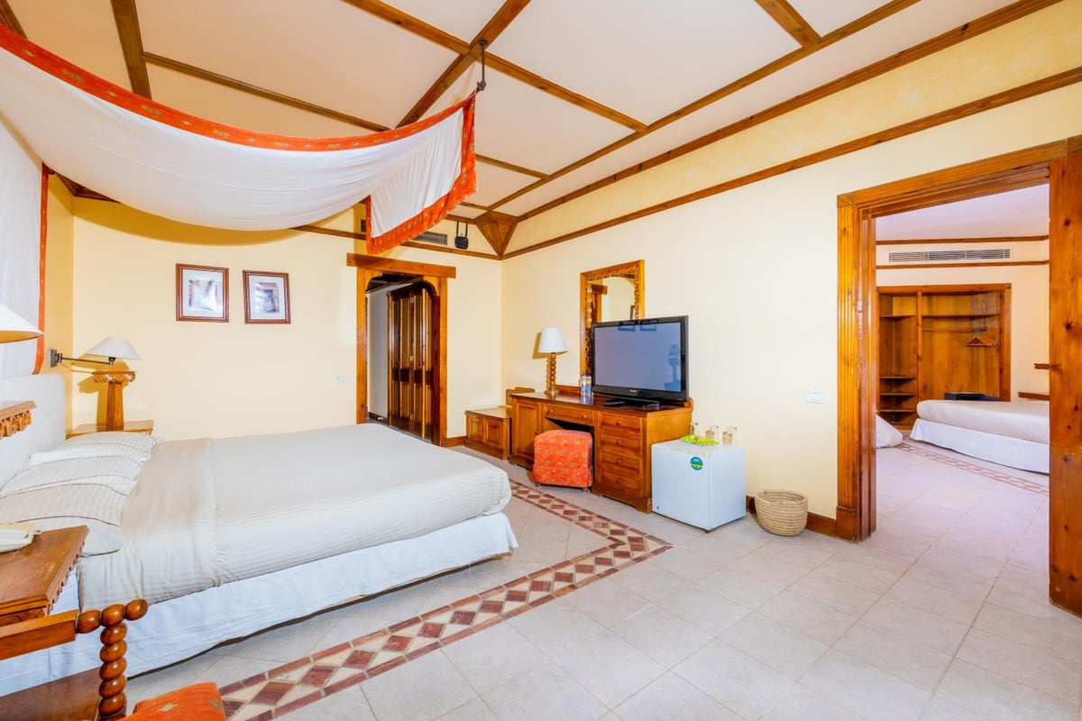 The Grand Resort Hurghada guest bedroom with a draped canopy and an open doorway to another bedroom.