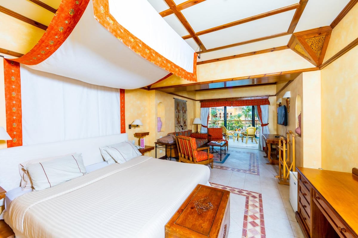 The Grand Resort Hurghada guest room with a draped ceiling and sitting area.