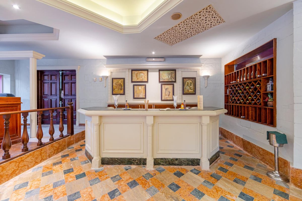 The Grand Resort Hurghada reception with a patterned tile floor and wooden wine rack.