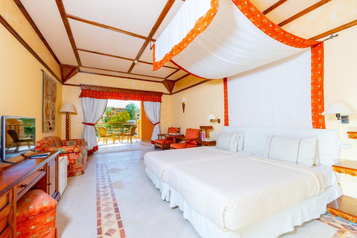 The Grand Resort Hurghada bedroom with a draped canopy and balcony doors.