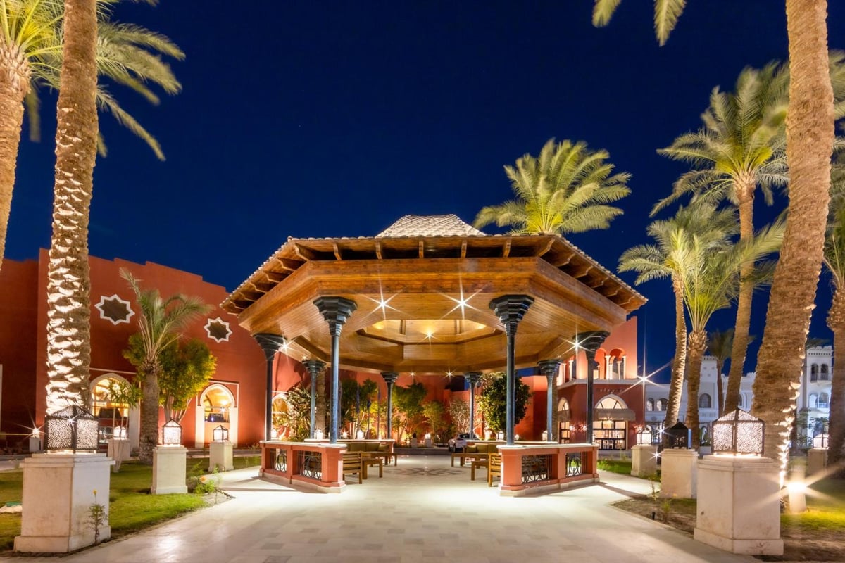 The Grand Resort Hurghada entrance pavilion with a timber roof and palm trees.