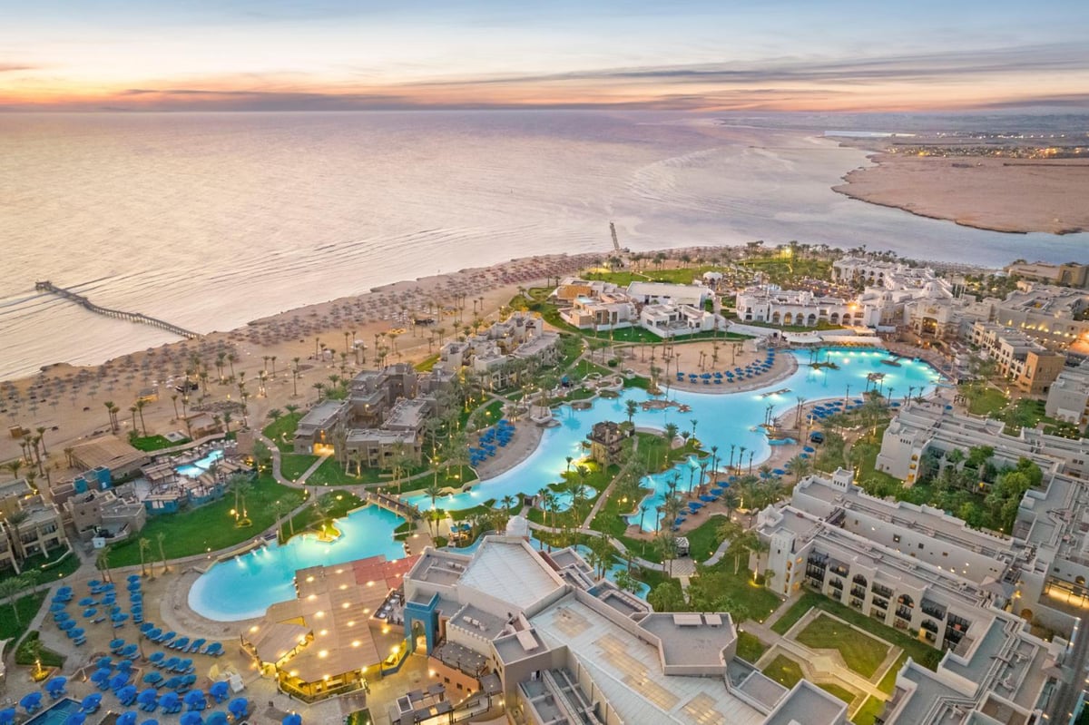 Pickalbatros Sands Port Ghalib resort grounds with lagoon pools and a sandy beach.