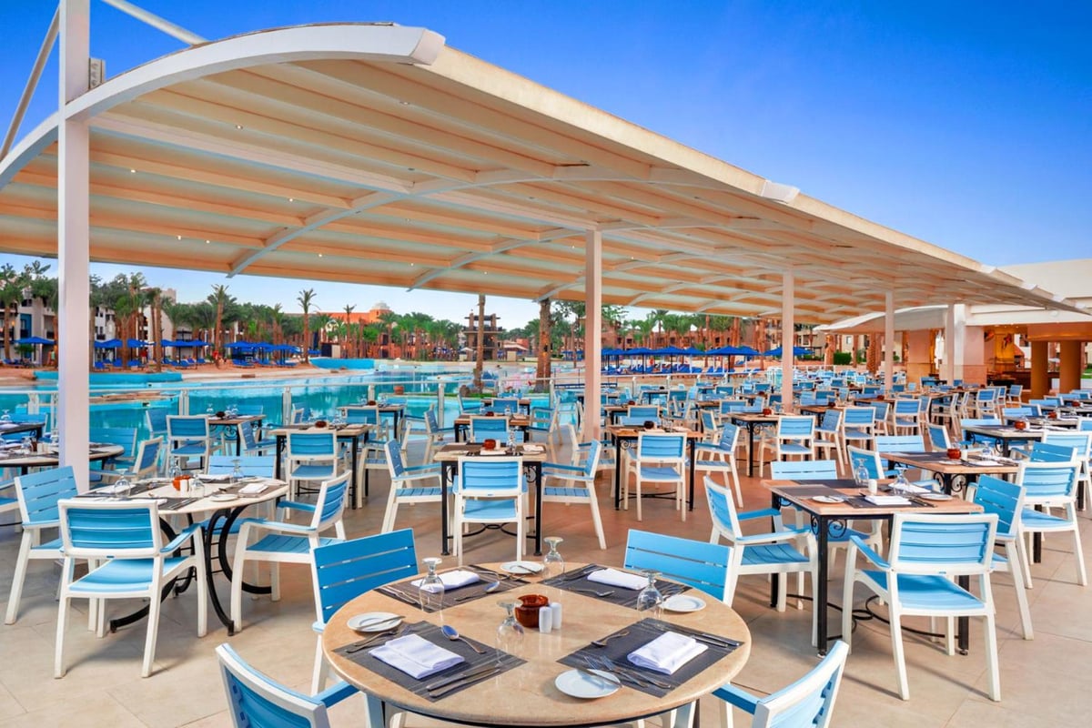 Pickalbatros Sands Port Ghalib dining terrace with a white canopy and poolside view.