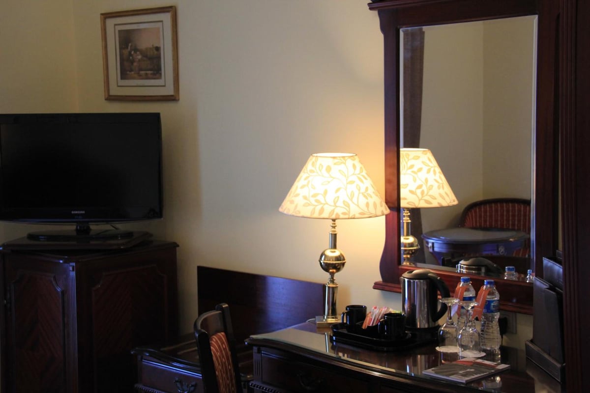 Steigenberger Cecil Hotel Alexandria guest room with a writing desk and large mirror.