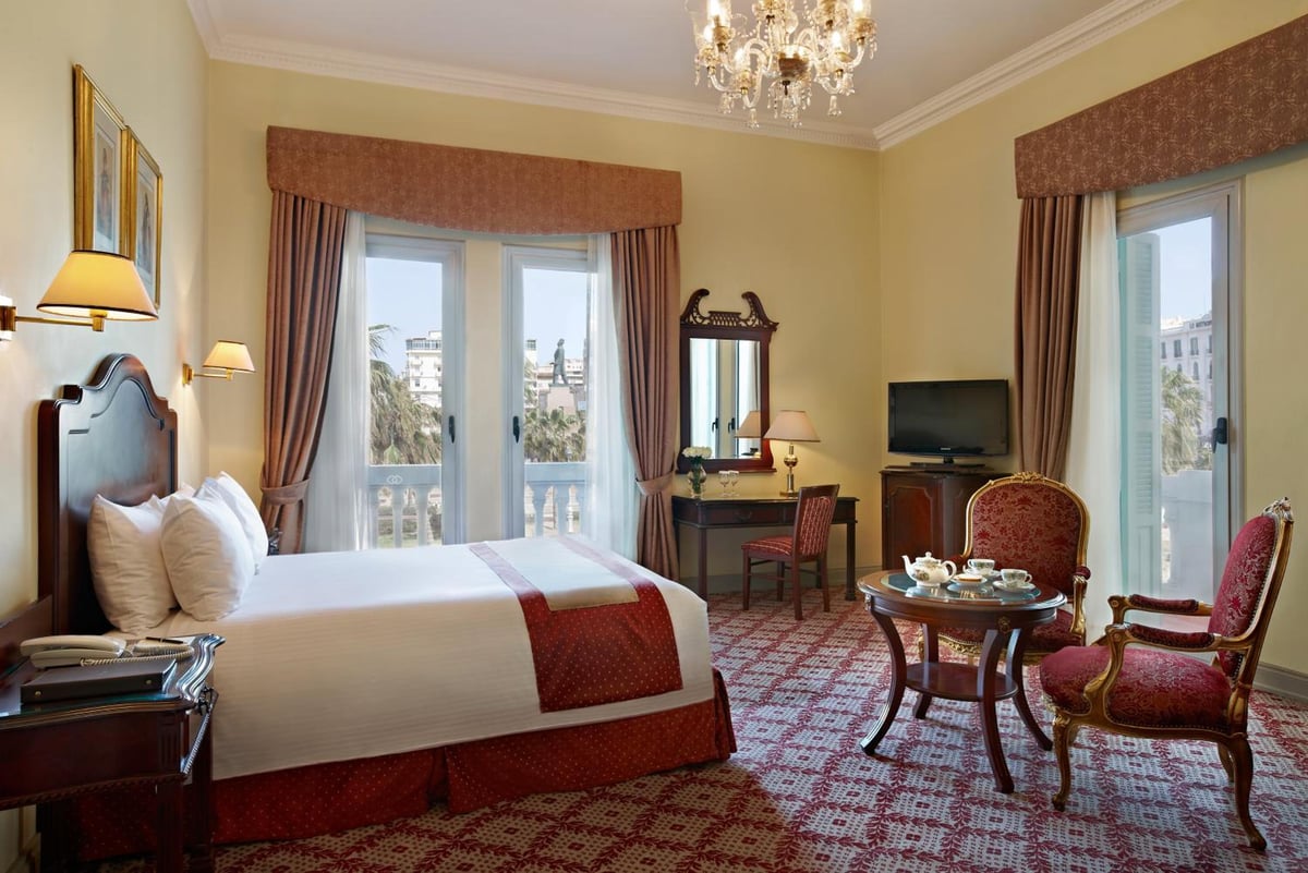 Steigenberger Cecil Hotel Alexandria guest room with balcony doors and patterned carpet.