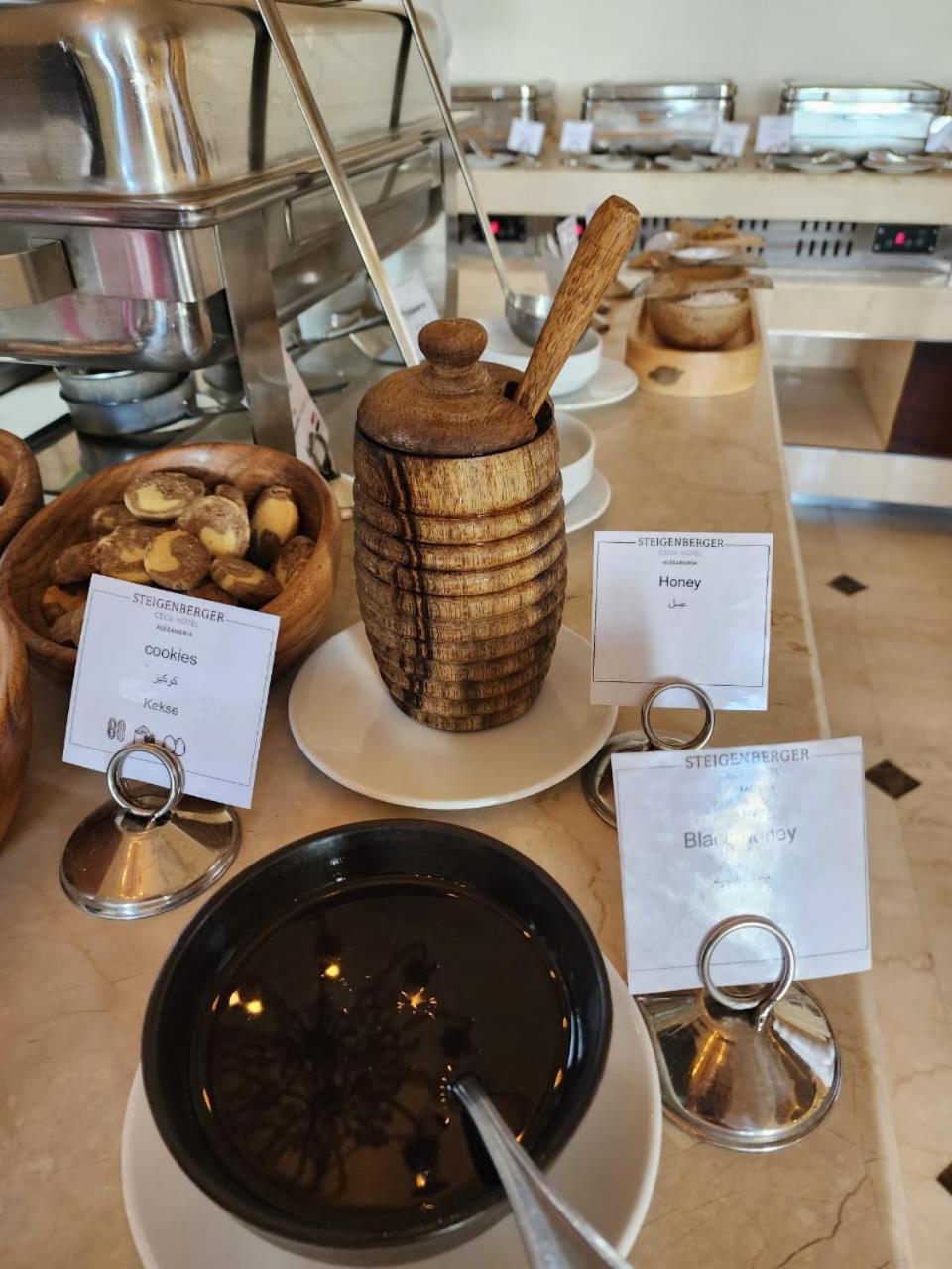 Steigenberger Cecil Hotel Alexandria buffet counter with a wooden honey pot and serving dishes.