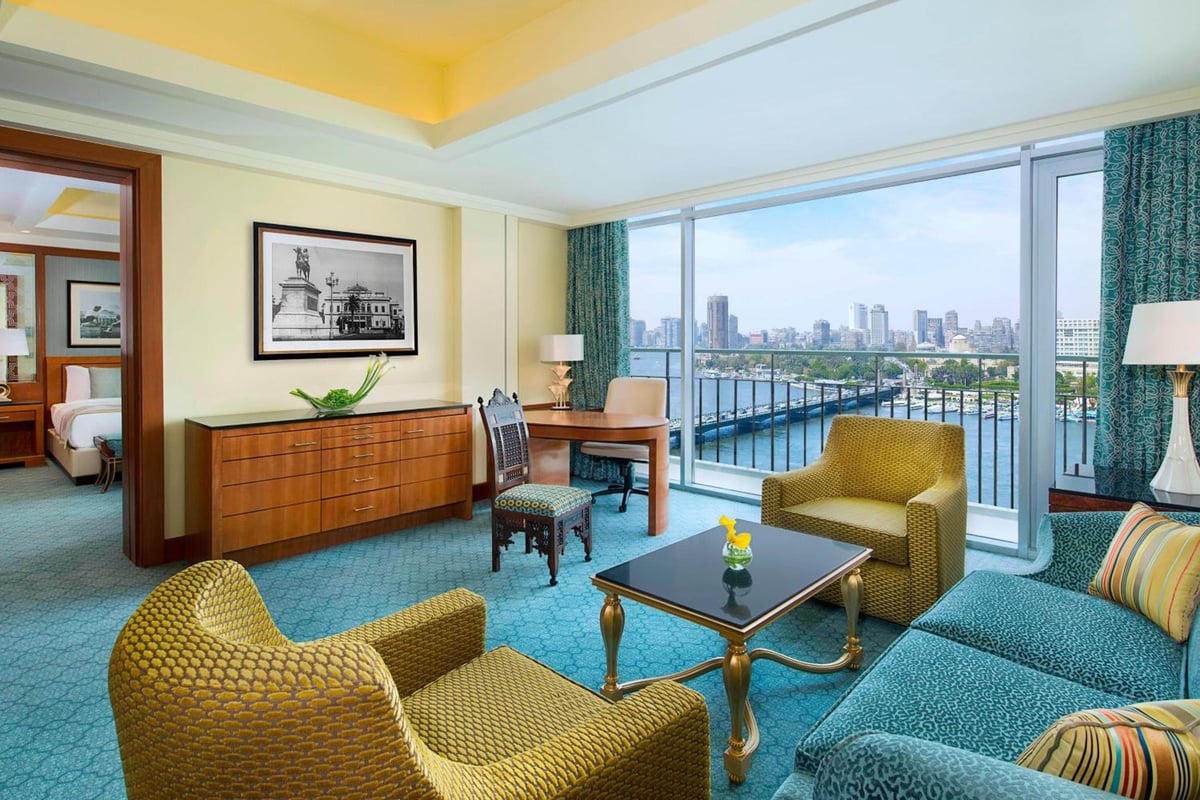 Nile Ritz-Carlton Cairo suite living room with patterned seating and floor-to-ceiling windows.