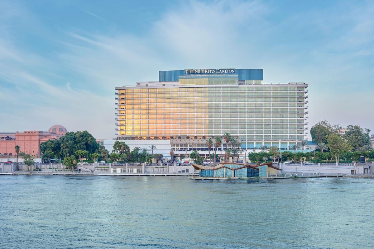 Nile Ritz-Carlton Cairo exterior from the river with glass facade and riverside promenade.