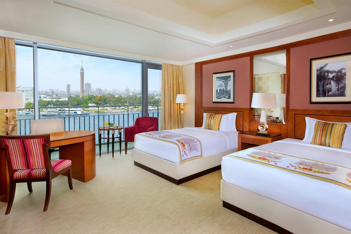 Nile Ritz-Carlton Cairo guest room with twin beds and river view.