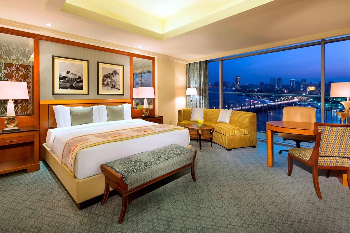 Nile Ritz-Carlton Cairo guest room with large bed and river view.