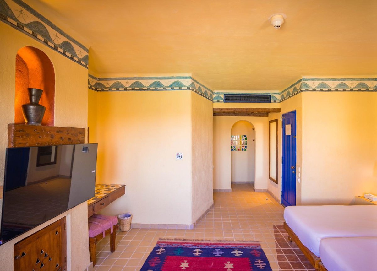 Marina Lodge at Port Ghalib guest room with a tiled floor and an arched doorway.