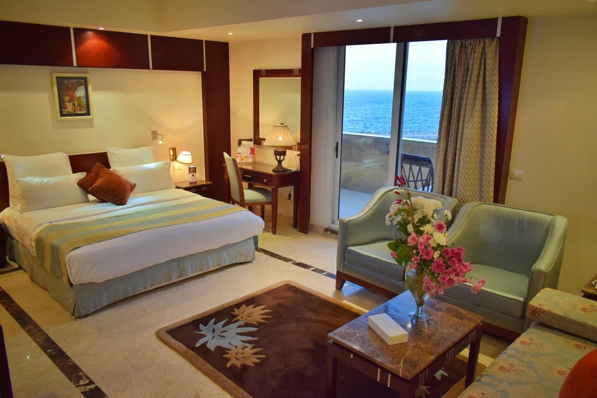 Romance Alexandria Hotel guest room with a bed and a sea-view balcony.