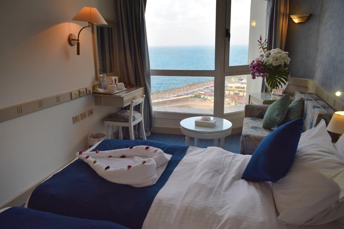 Romance Alexandria Hotel guest room with a bed and sea view.
