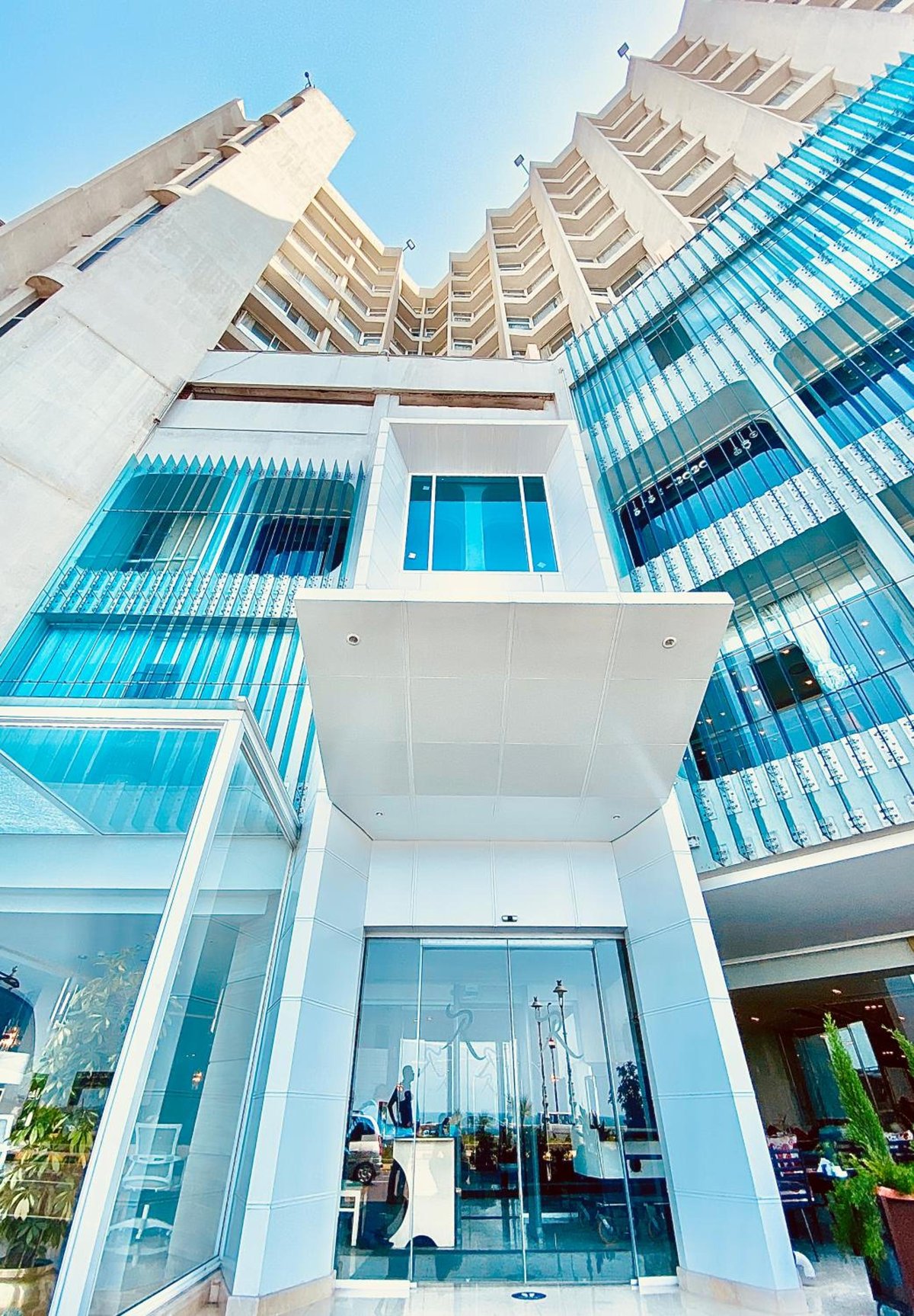 Romance Alexandria Hotel entrance with a glass facade and balconies.