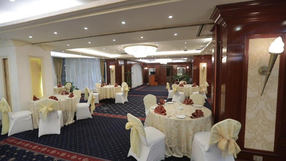 Romance Alexandria Hotel banquet dining room with round tables and white chair covers.