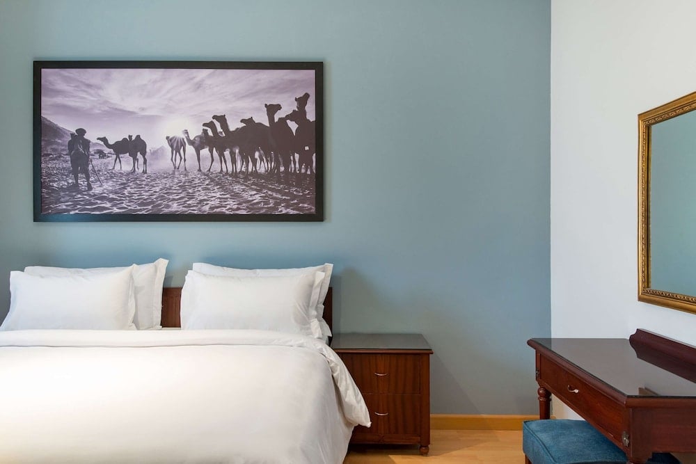Marina Resort Port Ghalib bedroom with a white bed and framed wall art.