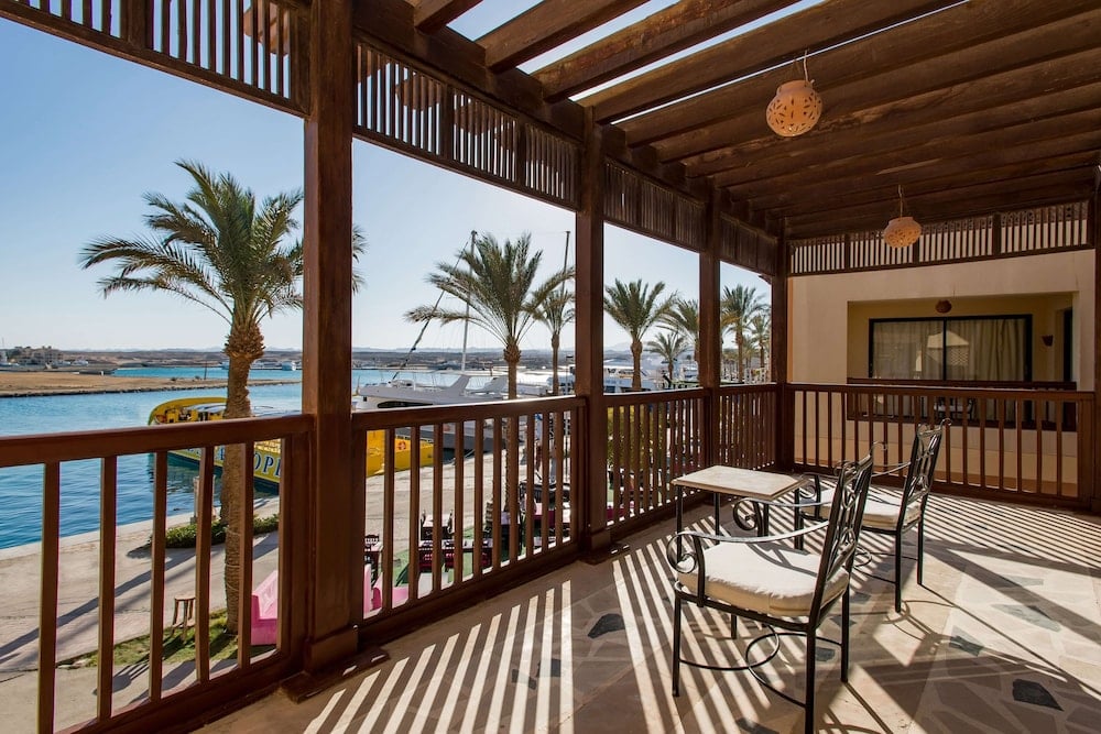 Marina Resort Port Ghalib covered terrace with wooden railings and a water view.