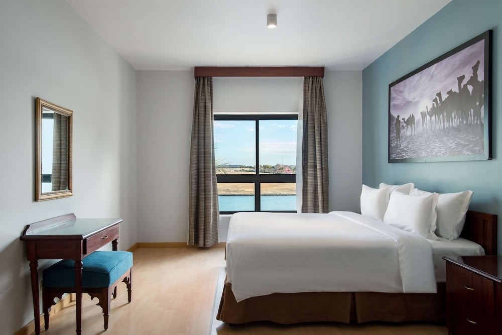 Marina Resort Port Ghalib bedroom with a large bed and a water view.