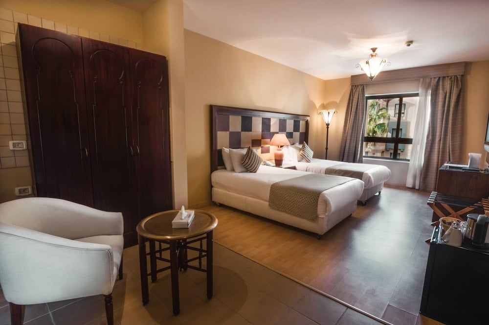Marina Resort Port Ghalib twin bedroom with two beds and a tiled headboard.