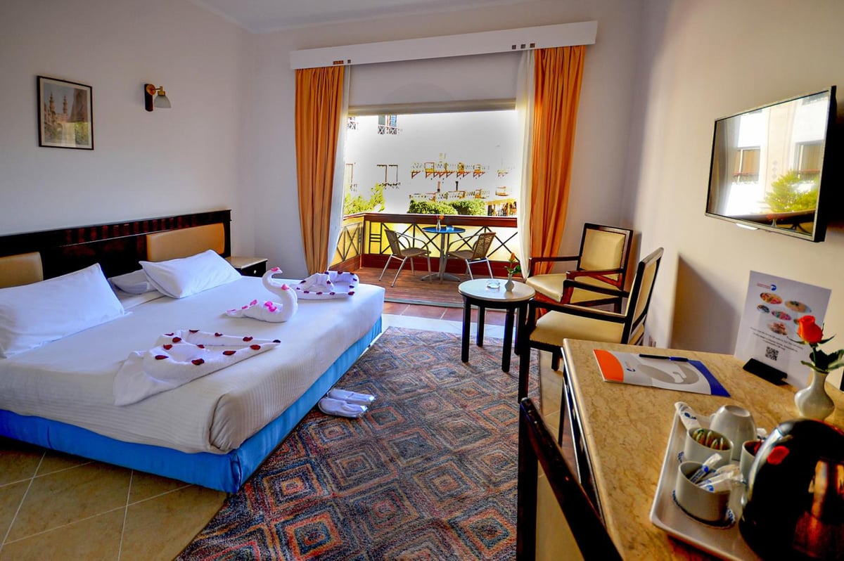 Falcon Naama Star Hotel guest room with a double bed and balcony seating.