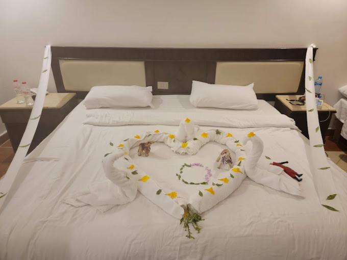 Falcon Naama Star Hotel bedroom with white bedding and a folded towel display.