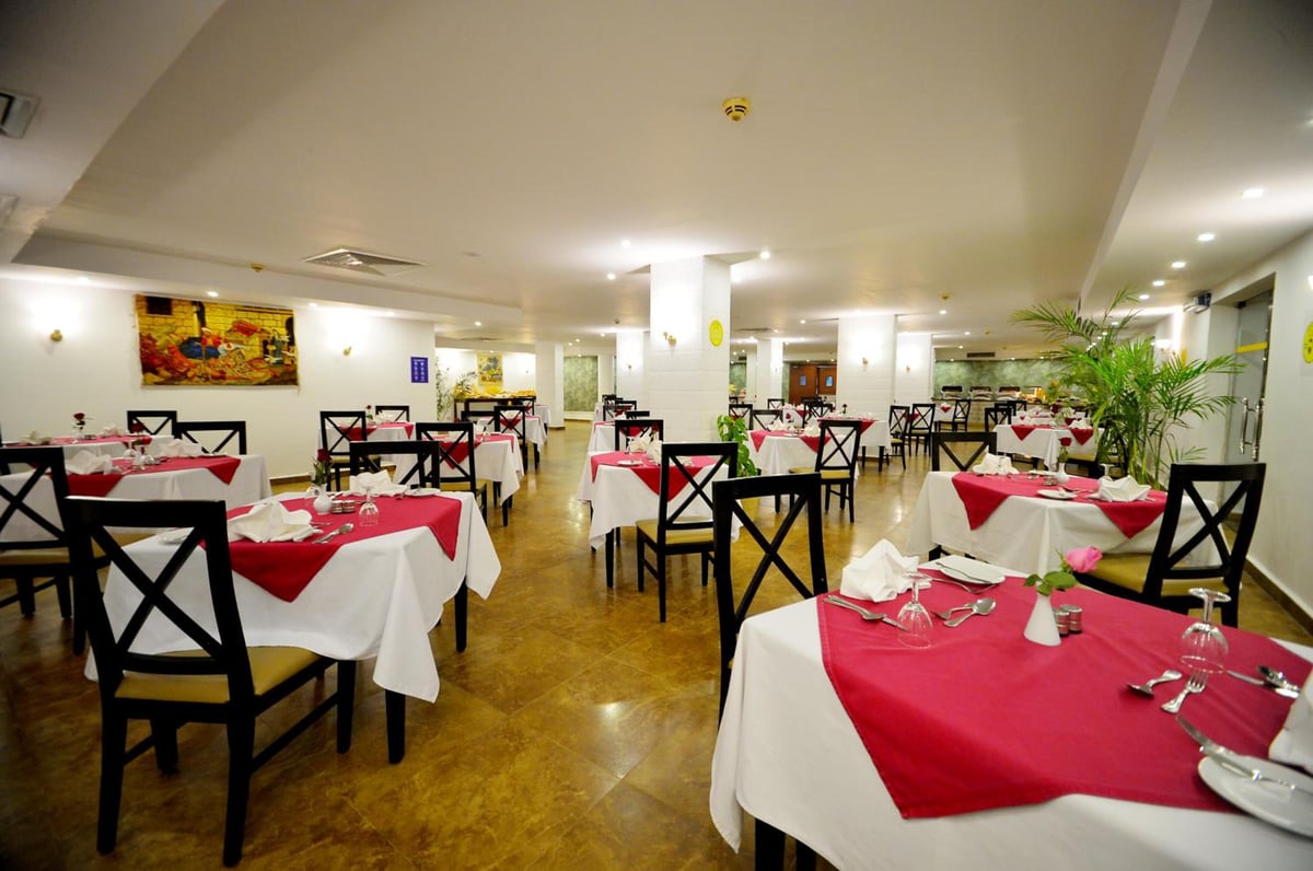 Falcon Naama Star Hotel dining room with red table runners and black chairs.