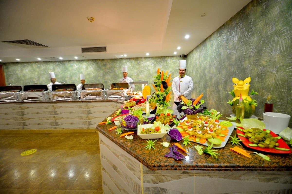 Falcon Naama Star Hotel buffet counter with food displays and chefs behind it.