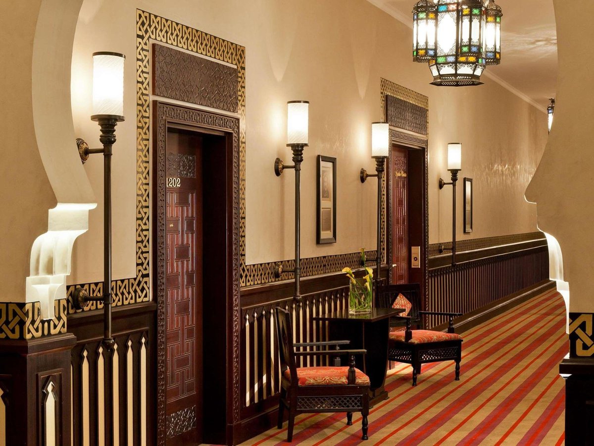 Sofitel Old Cataract corridor with carved wooden doors and striped carpet.