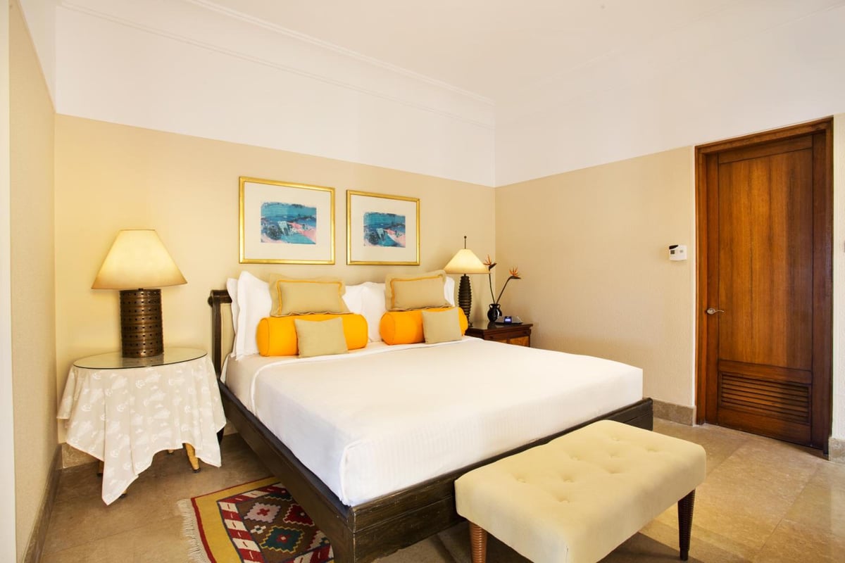 The Oberoi Sahl Hasheesh bedroom with a large bed and framed artwork.