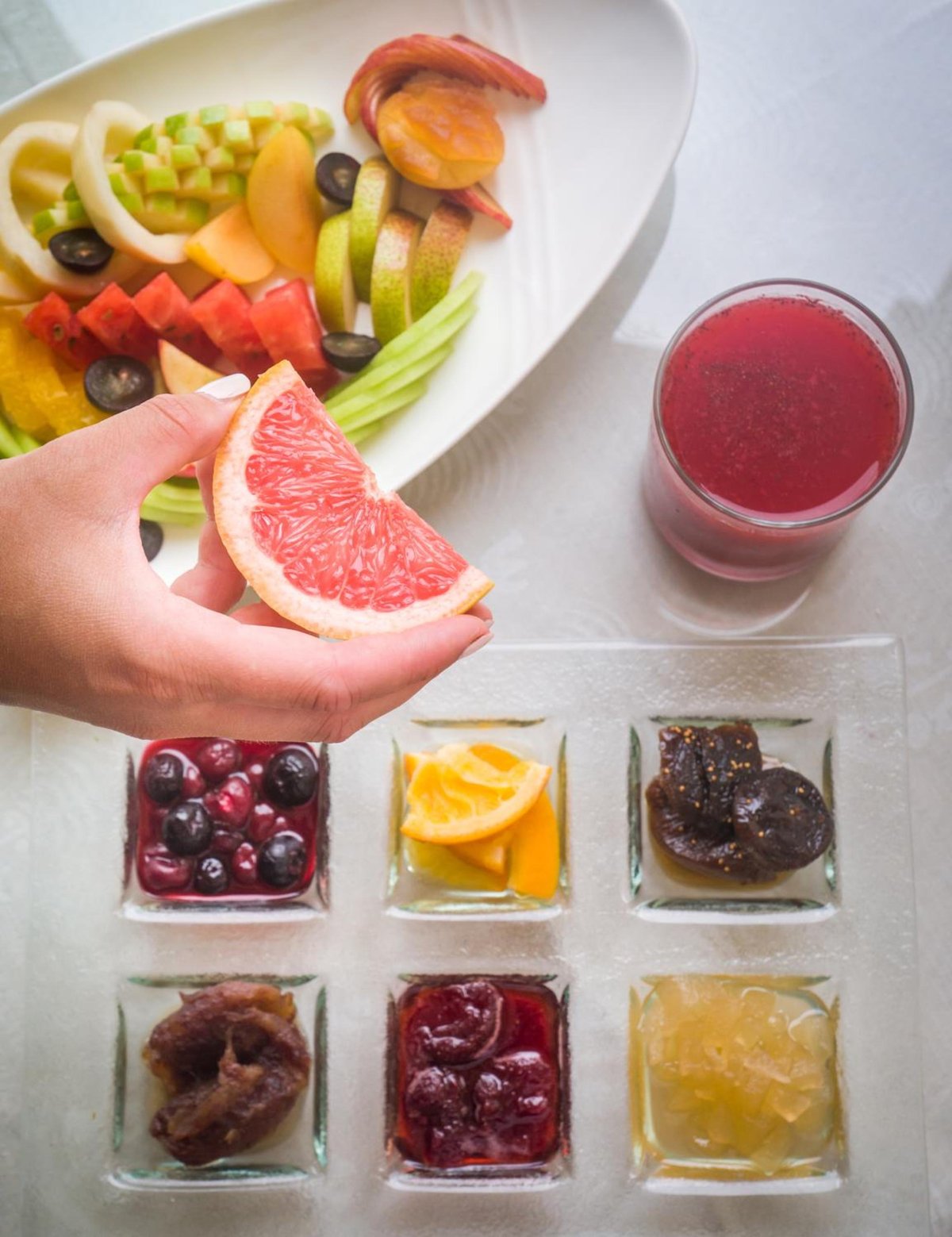 The Oberoi Sahl Hasheesh breakfast table with a fruit platter and juice.