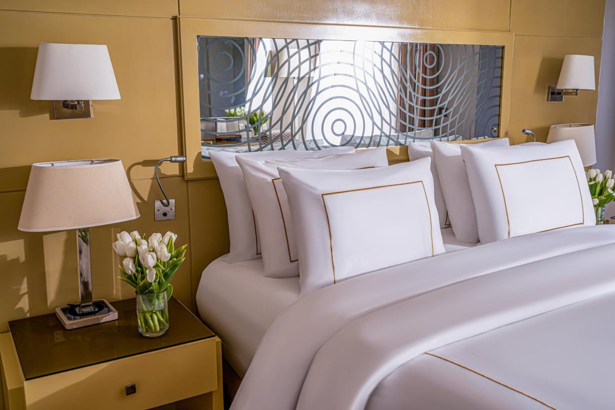Rixos Premium Seagate bedroom with a white bed and patterned wall panel.
