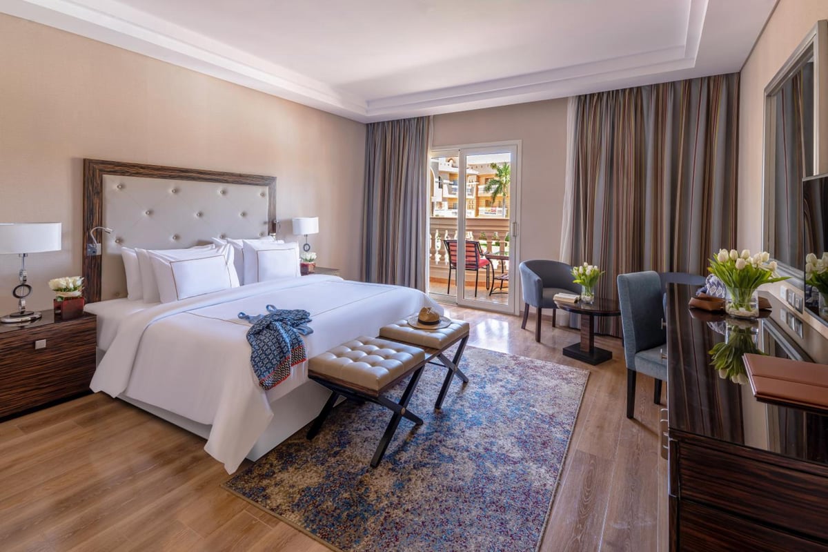 Rixos Premium Seagate guest room with a bed and a sitting area.