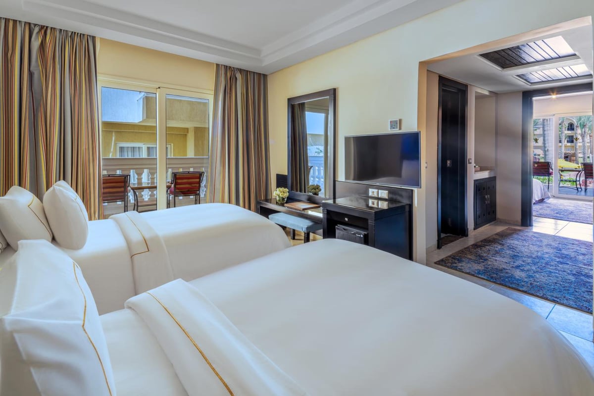 Rixos Premium Seagate guest room with twin beds and sliding doors to a balcony.