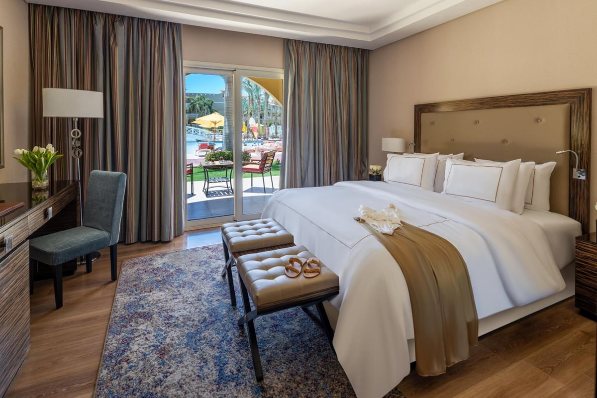 Rixos Premium Seagate guest room with a large bed and sliding glass doors.