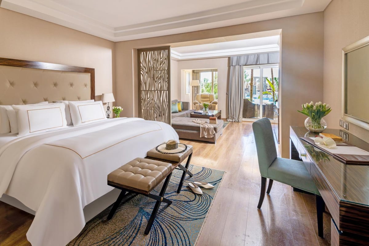 Rixos Premium Seagate bedroom with a large bed and adjoining sitting area.