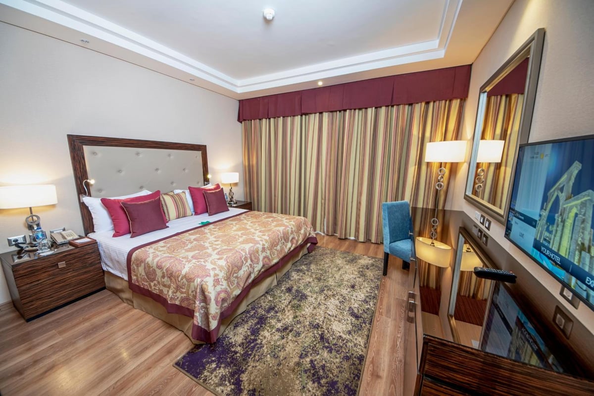Rixos Premium Seagate bedroom with an upholstered bed and patterned curtains.