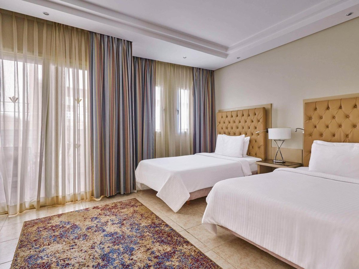 Rixos Premium Seagate twin bedroom with two beds and tufted headboards.