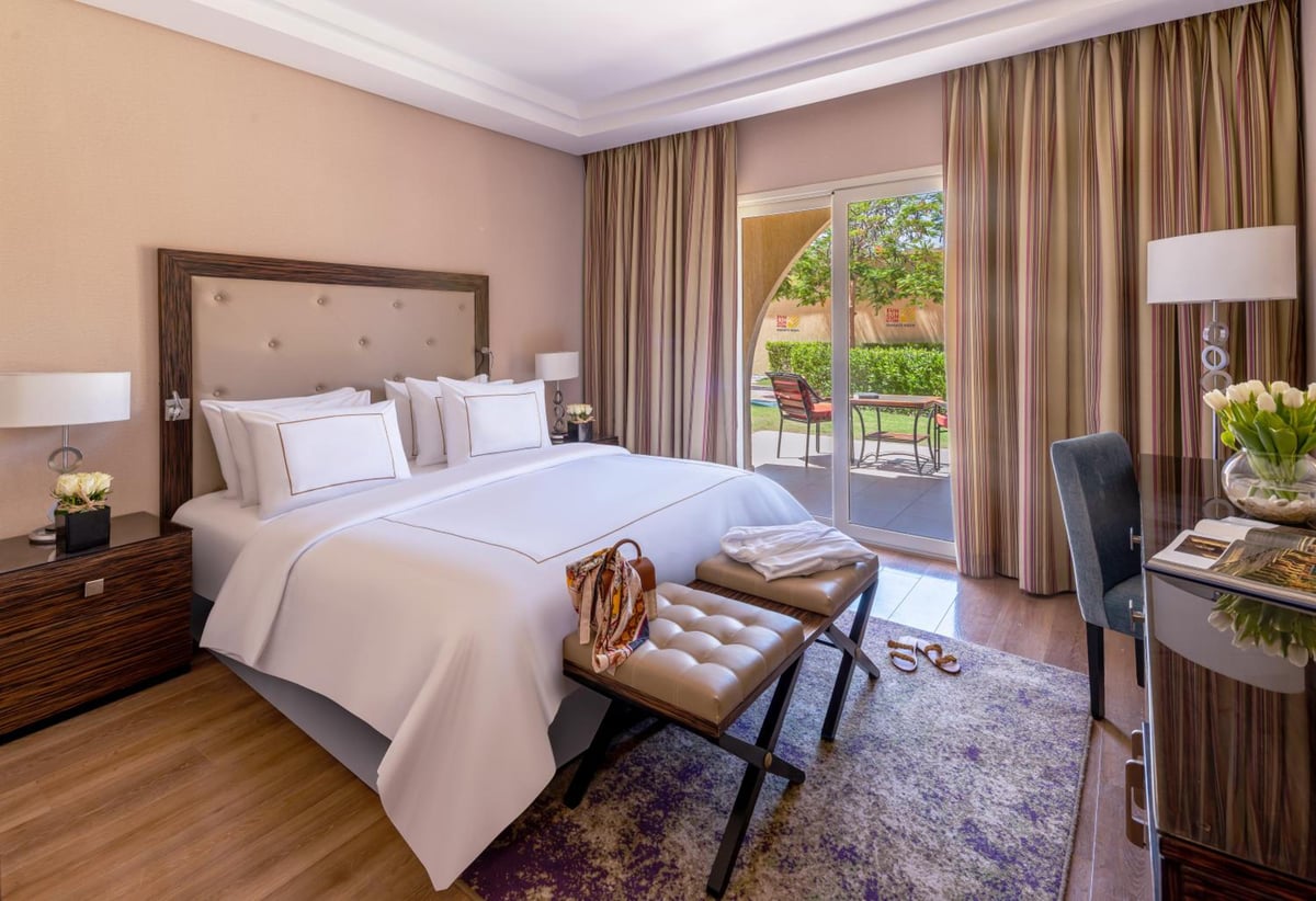 Rixos Premium Seagate bedroom with a large bed and sliding glass doors.