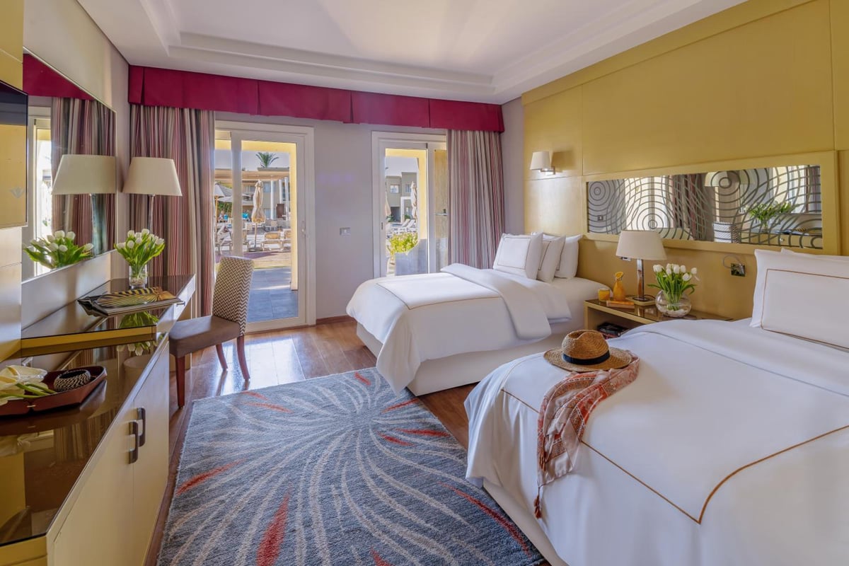 Rixos Premium Seagate twin bedroom with two beds and balcony doors.