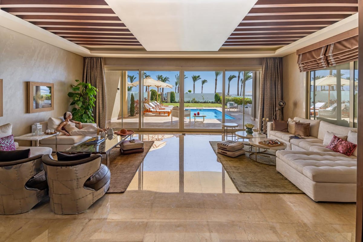 Rixos Premium Seagate living room with large windows and a pool view.