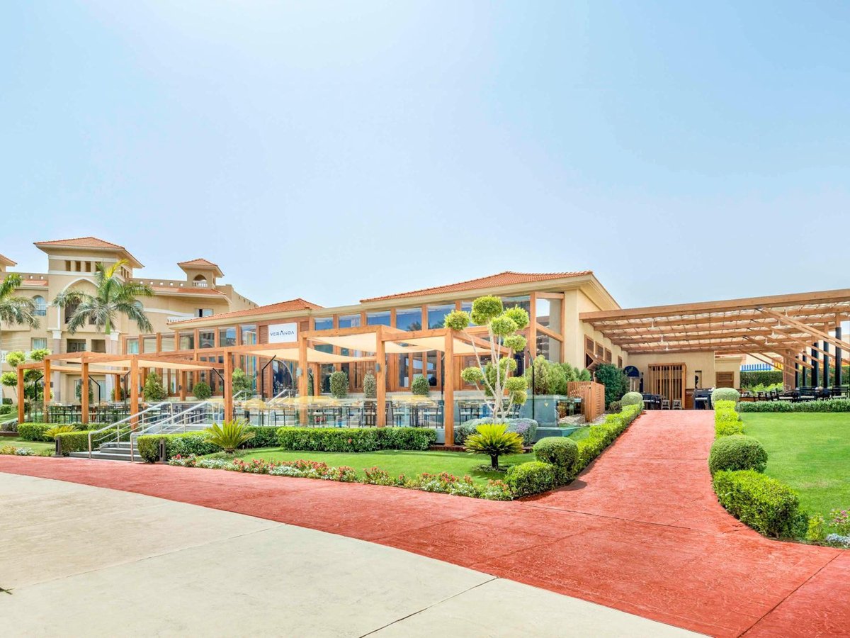 Rixos Premium Seagate garden entrance with a red path and wooden pergola.