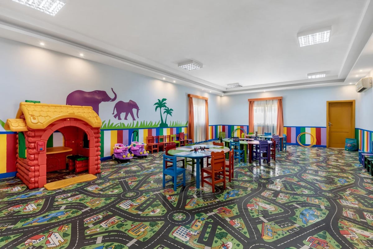 Rixos Premium Seagate children's playroom with a road-patterned carpet and animal mural.