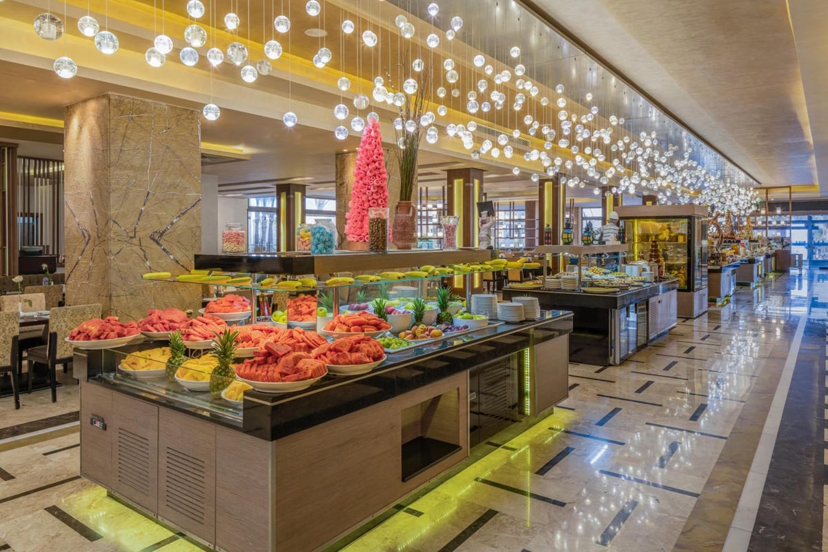 Rixos Premium Seagate buffet restaurant with food displays and hanging lights.