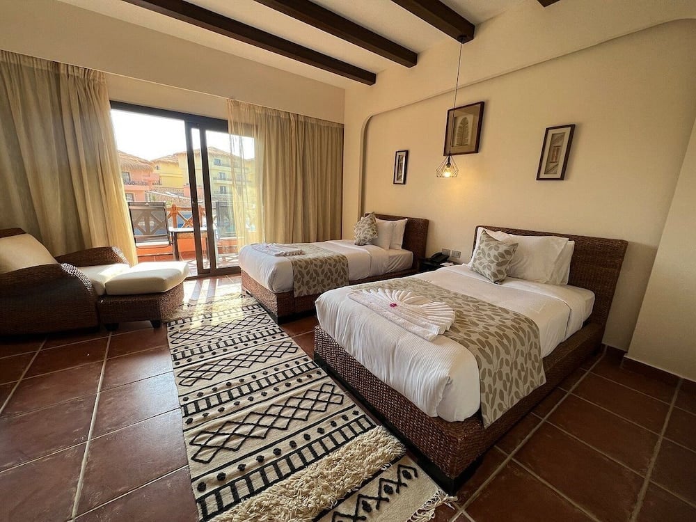Amarina Jannah Resort & Aqua Park twin bedroom with two beds and sliding glass doors to a balcony.