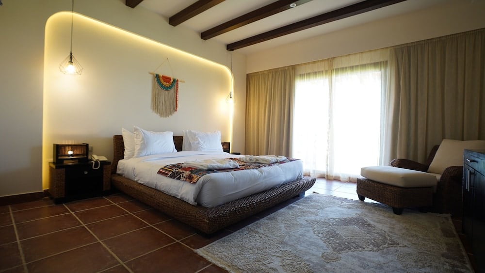 Amarina Jannah Resort & Aqua Park guest bedroom with a low bed and curtained windows.