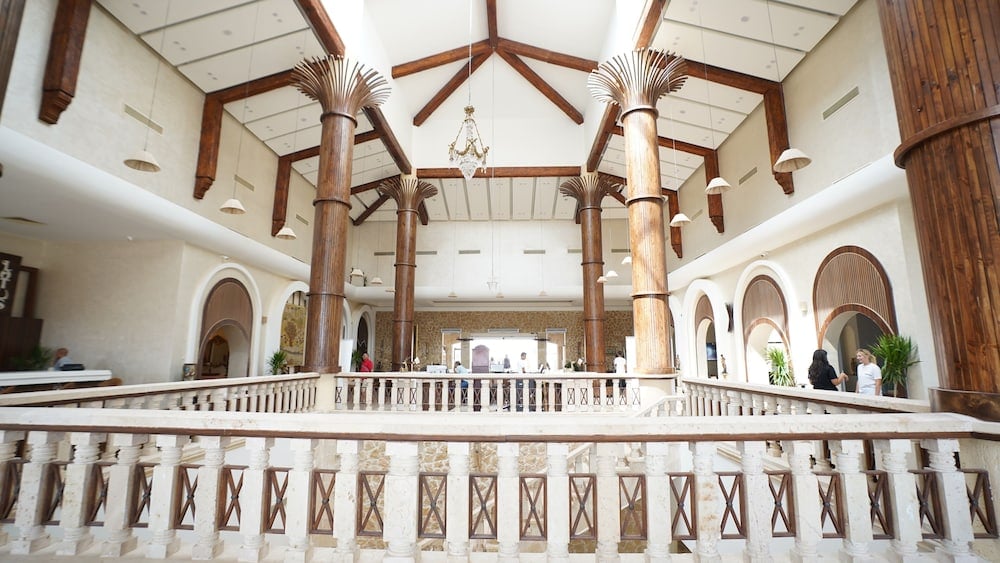 Amarina Jannah Resort & Aqua Park lobby with wooden columns and a high timber-beamed ceiling.