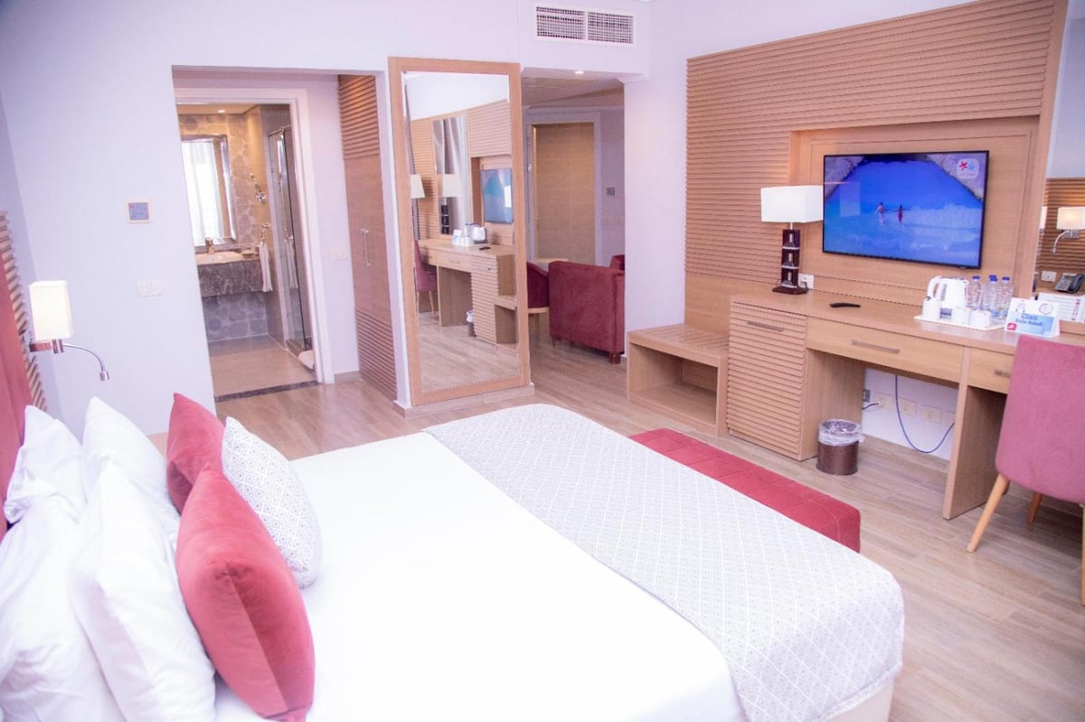 Stella Beach Resort & Spa Makadi Bay bedroom with a bed and a wall-mounted television.