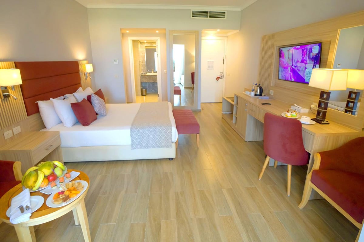 Stella Beach Resort & Spa Makadi Bay guest bedroom with a bed and a desk.